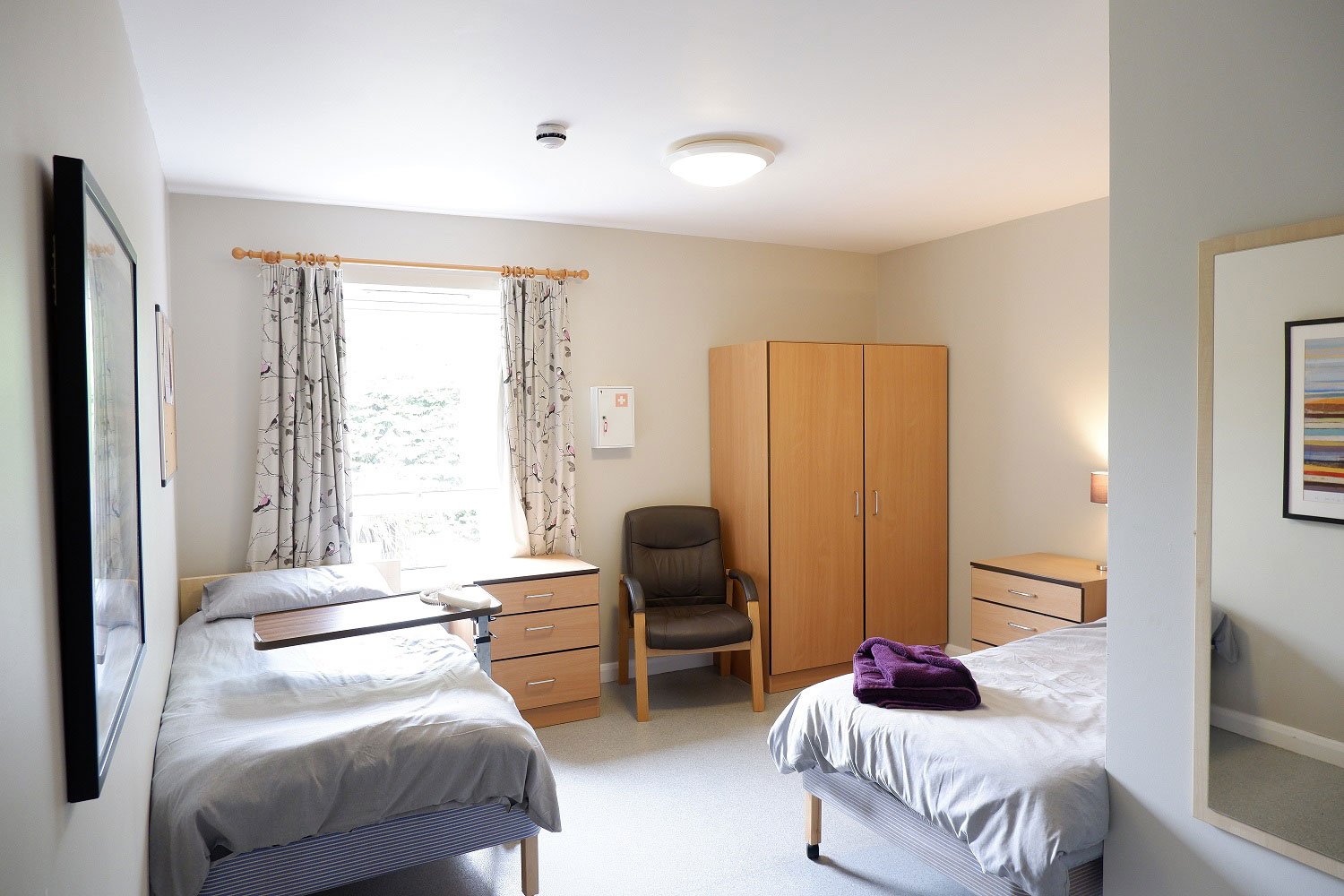 A photo of a room at Broadway Lodge containing two single beds, a wardrobe and cabinets