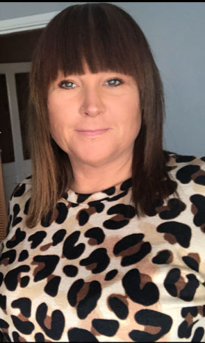 A woman wearing a leopard print top with shoulder length hair and a fringe