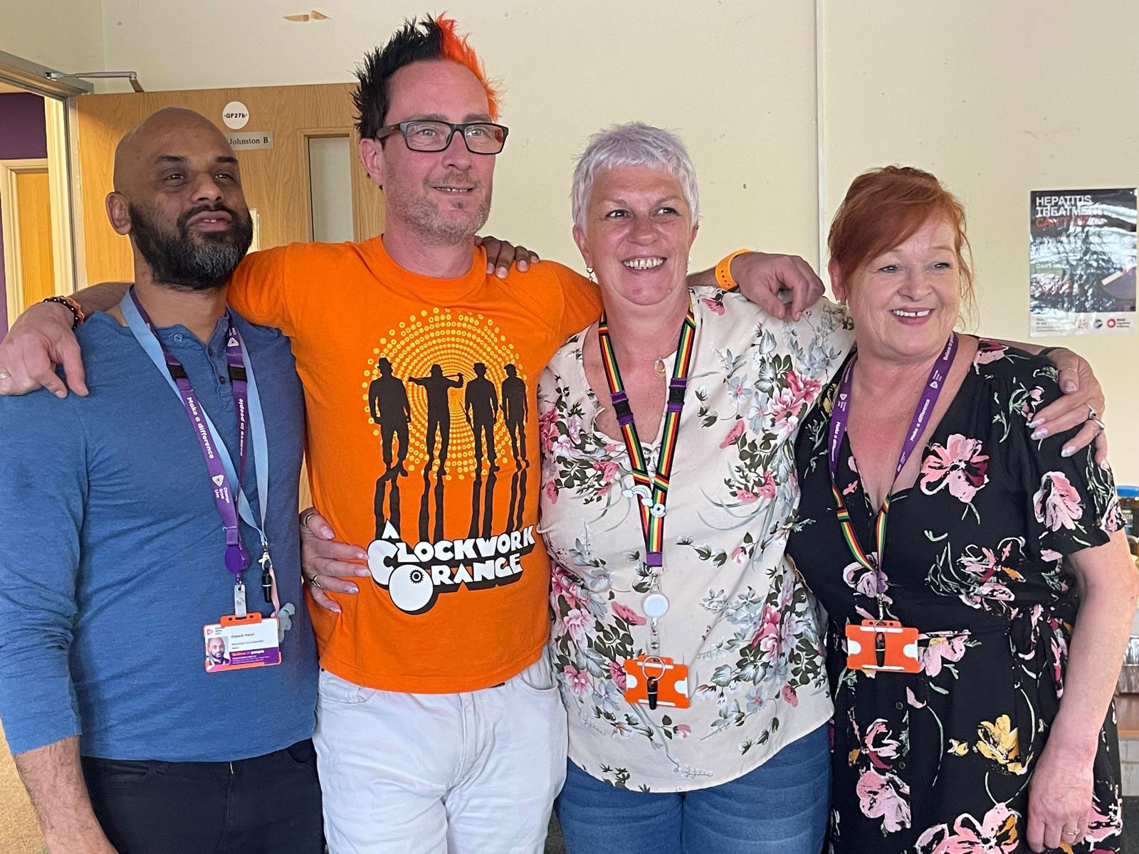 Four people stood with their arms around each other