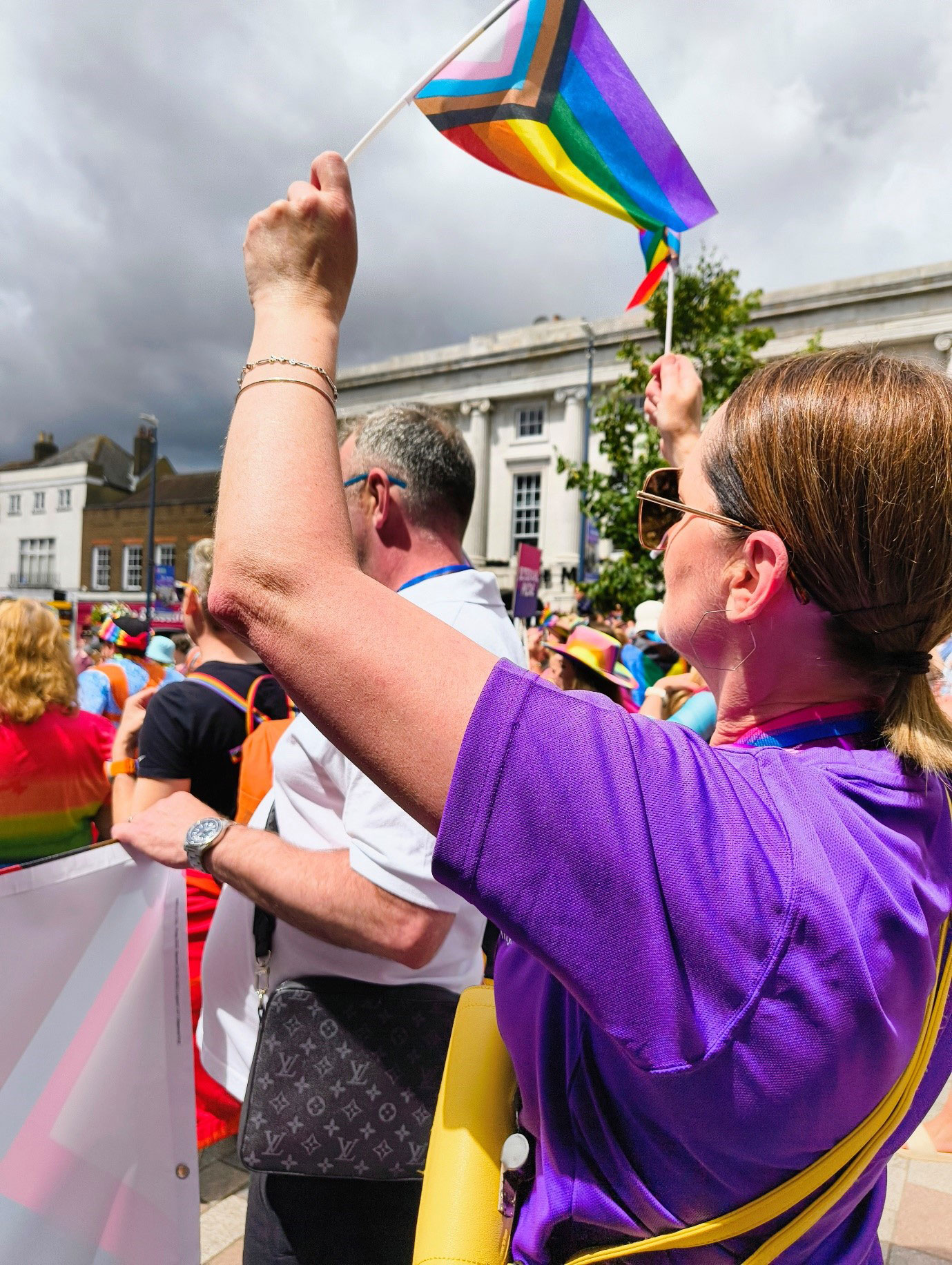 A women in a parade waving a pride flag