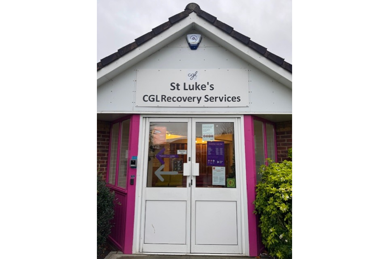 A white door with St Luke's CGL Recovery Service written above and a pointed roof