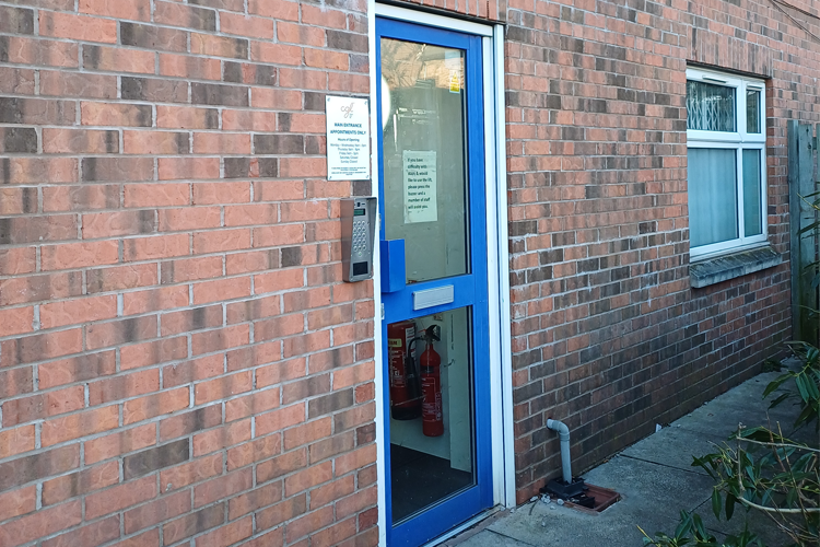 A blue door leading into a brick building