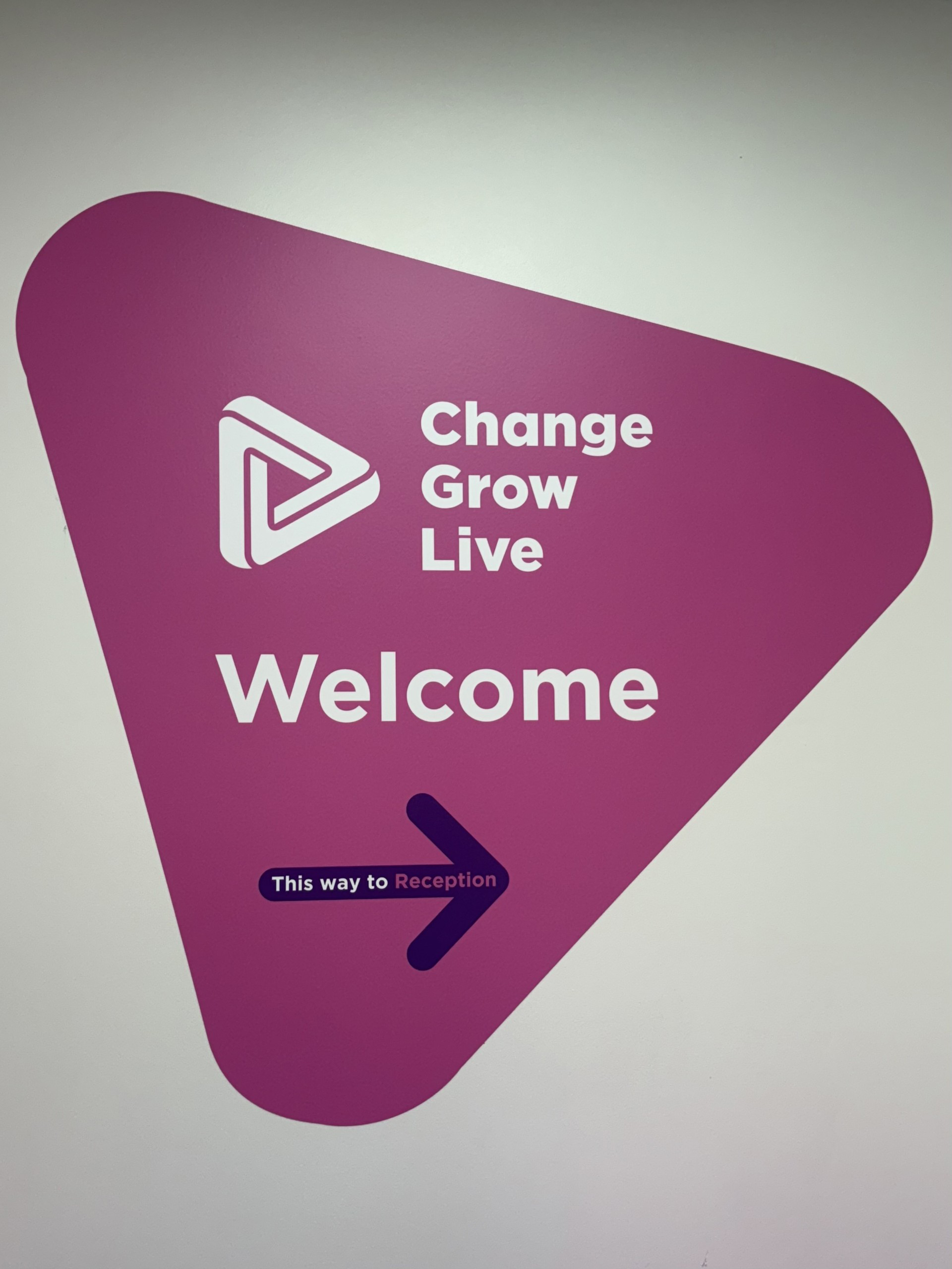 A pink triangle with the Change Grow Live logo and 'Welcome' with an arrow pointing right