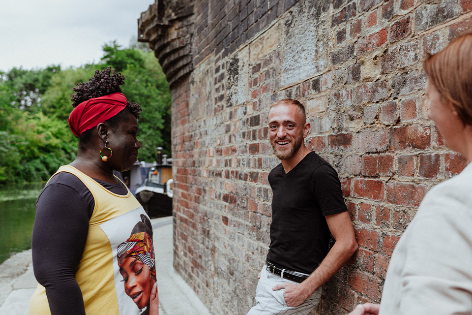 Three people talking with one looking and smiling at the camera