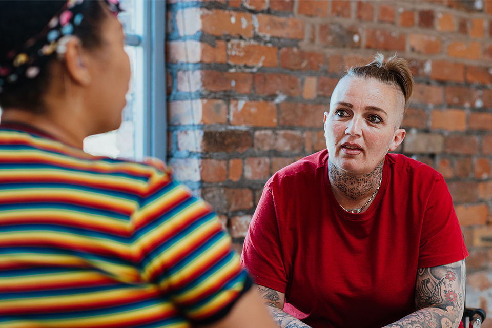 Two people in conversation with one slightly out of focus