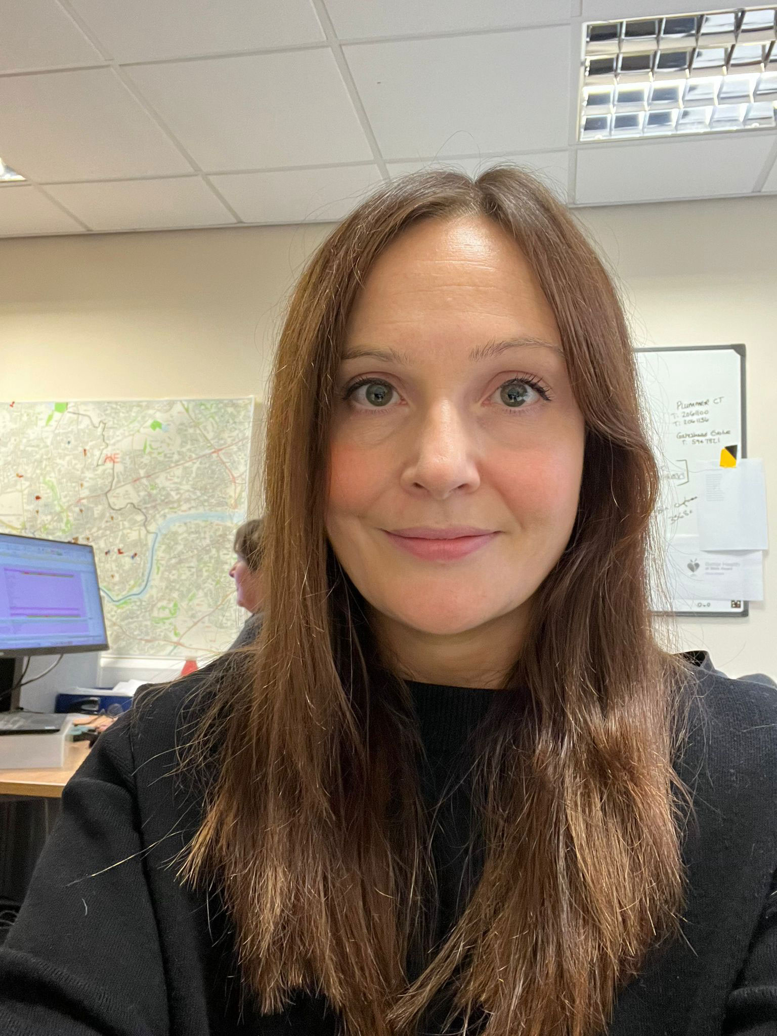 Eleni has long brown hair and is smiling at the camera
