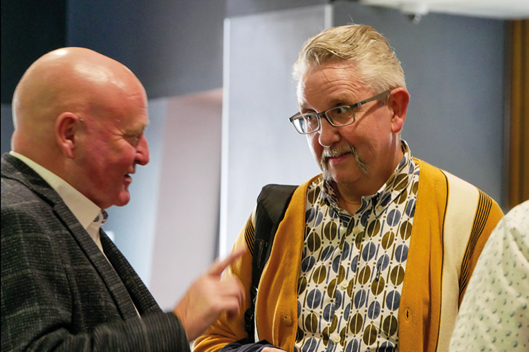 Two men talking to each other in a public setting