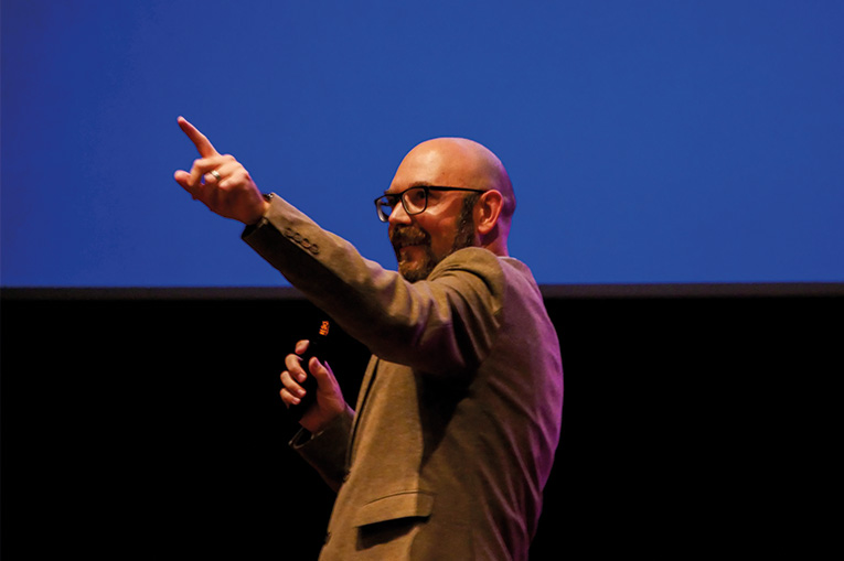 A man presenting to an audience and pointing