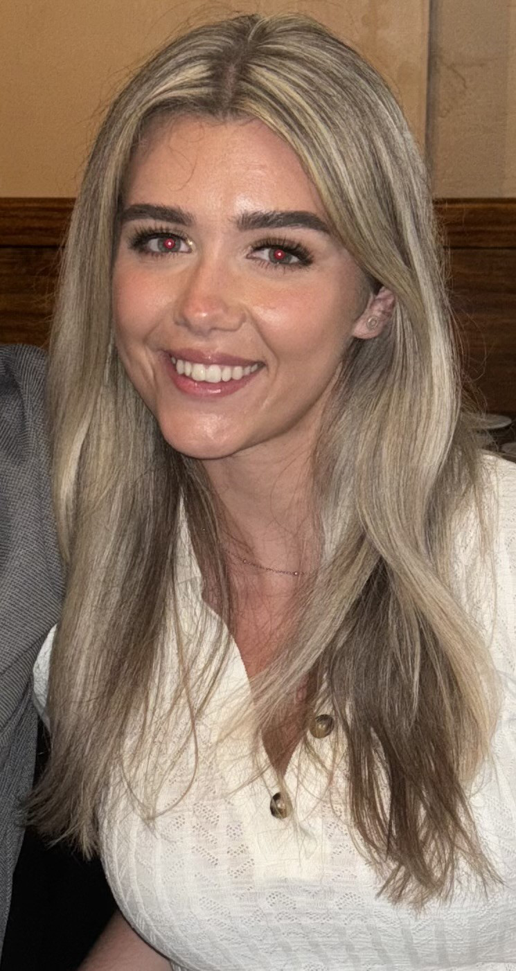 A young woman with long blonde hair and wearing a white shirt