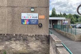 A sign for Team Family Hub on a concrete wall