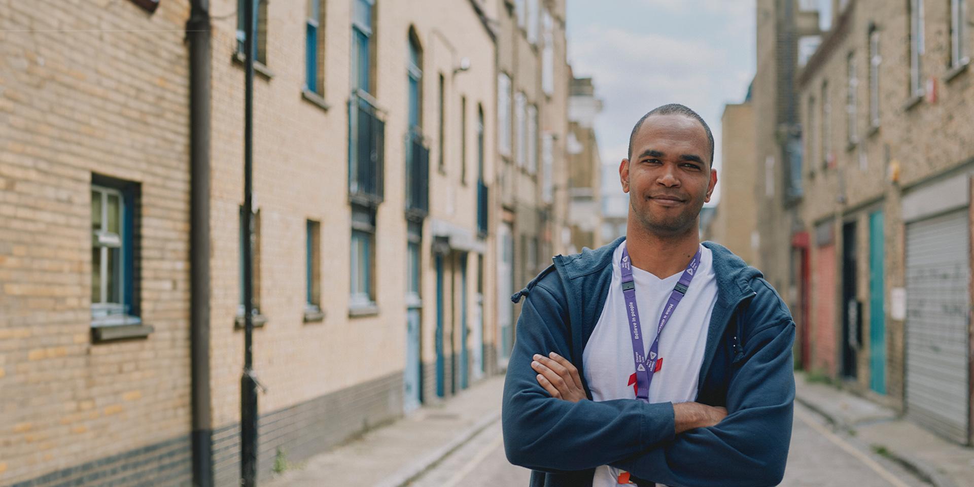 A person smiling stood in the street