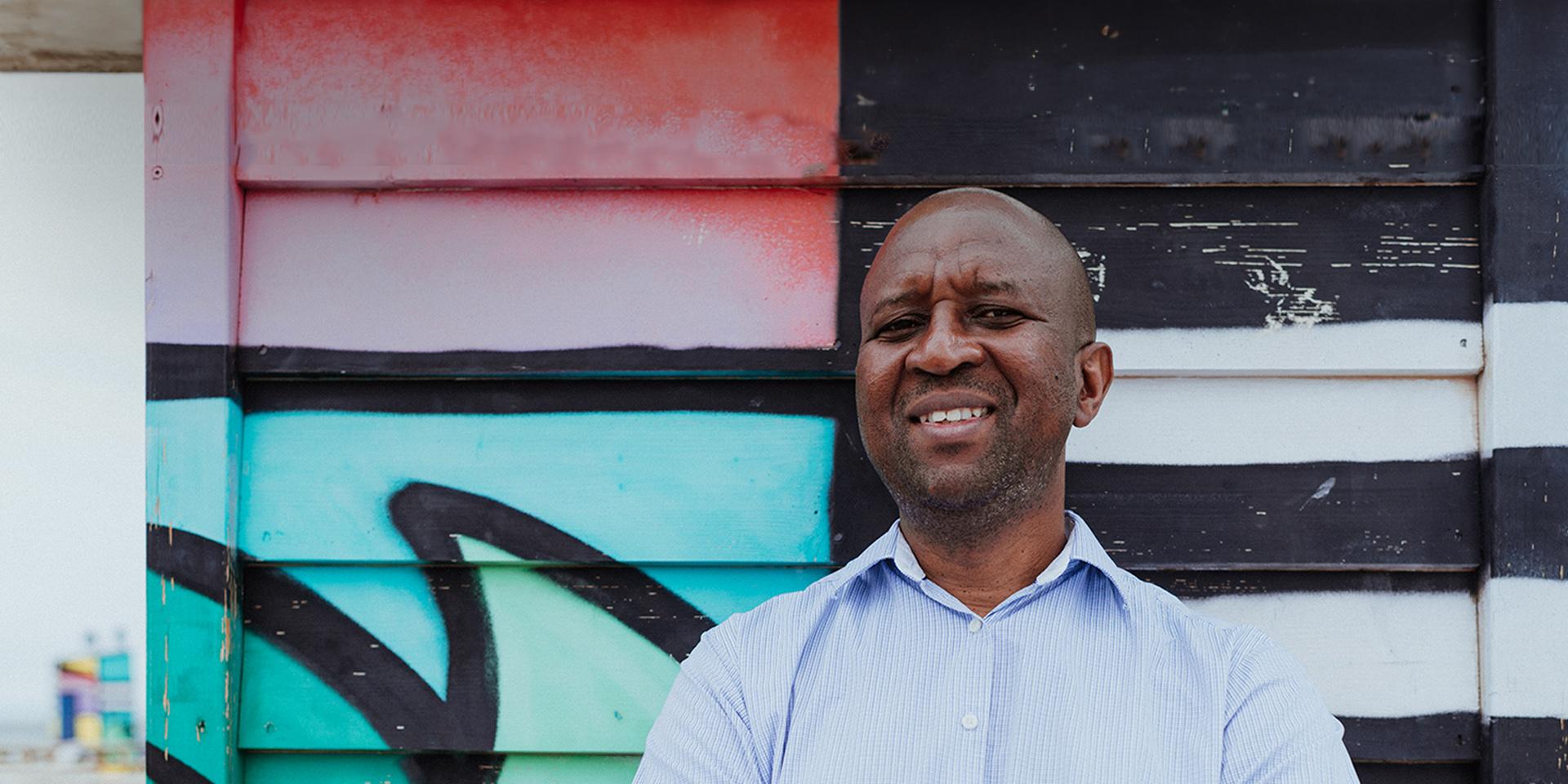 A person smiling outside and looking at the camera