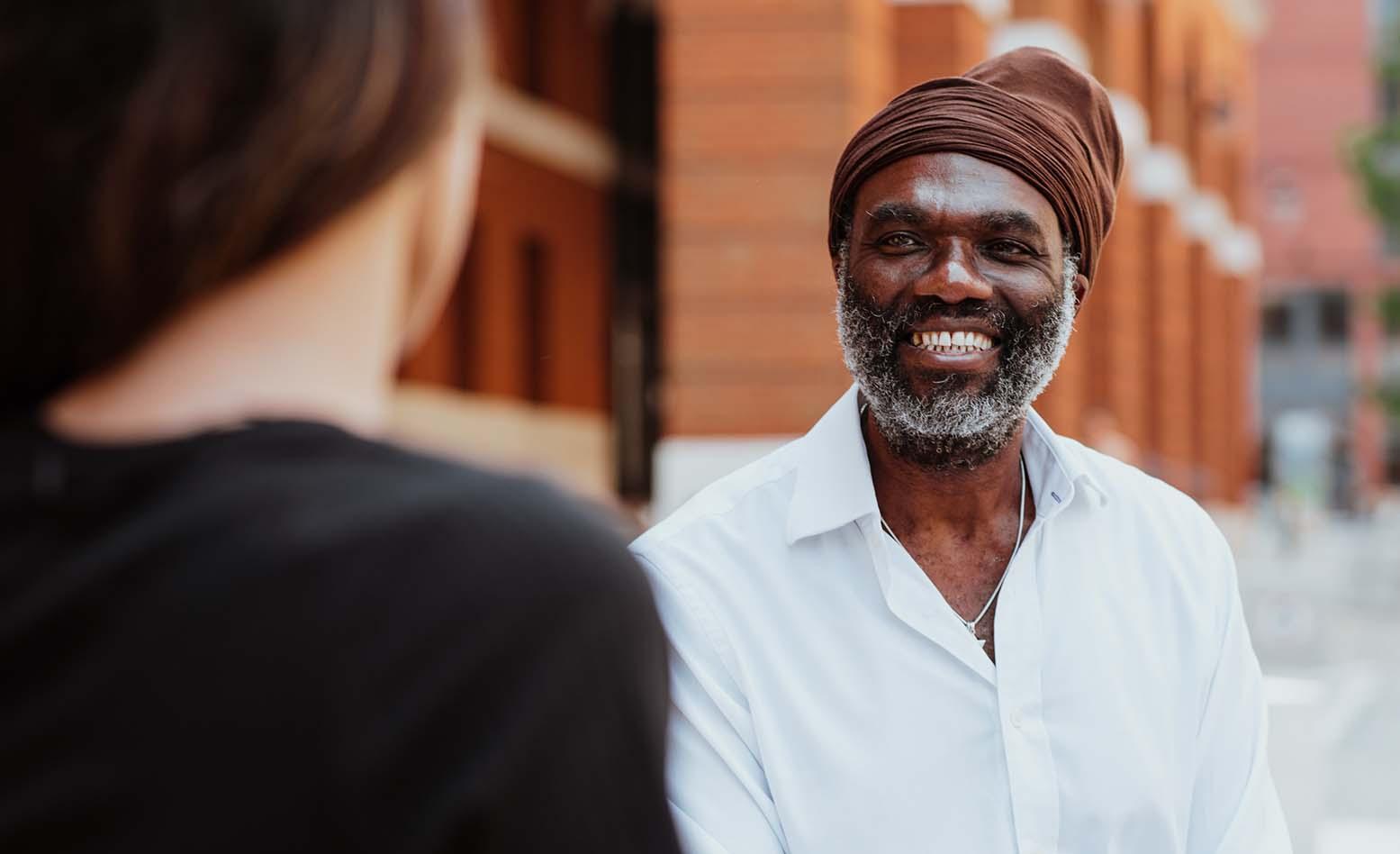 A man smiling stood outside