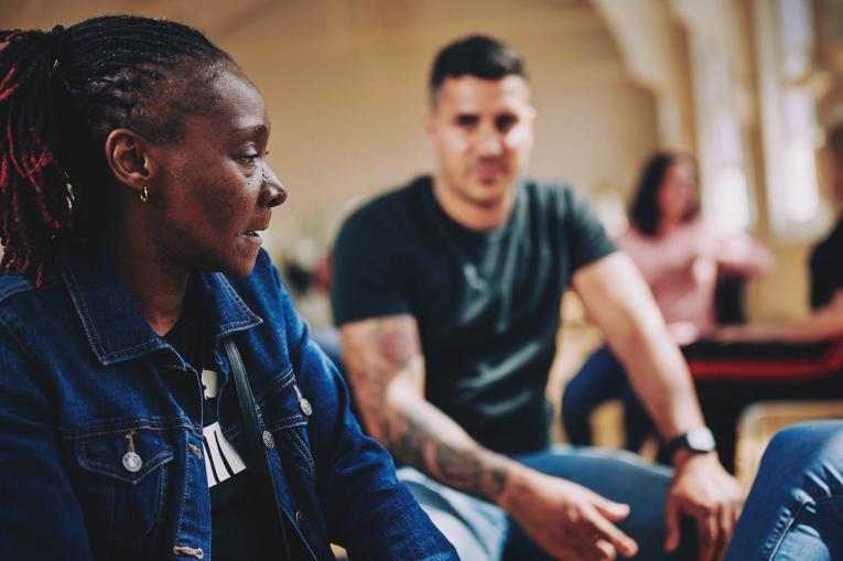 Two people are sitting having a conversation