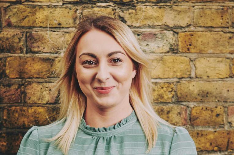 woman standing in front of a wall smiling