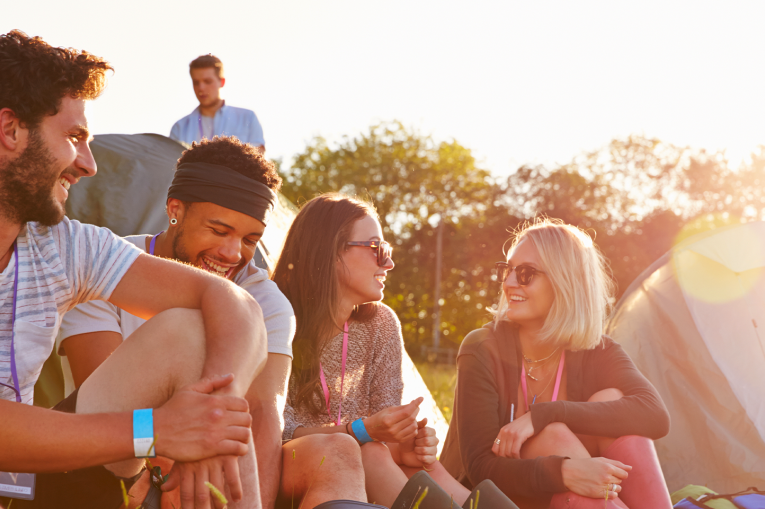 A group of young people at a festival smiling and laughing