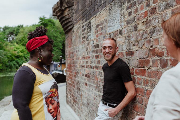 Three people talking with one looking and smiling at the camera