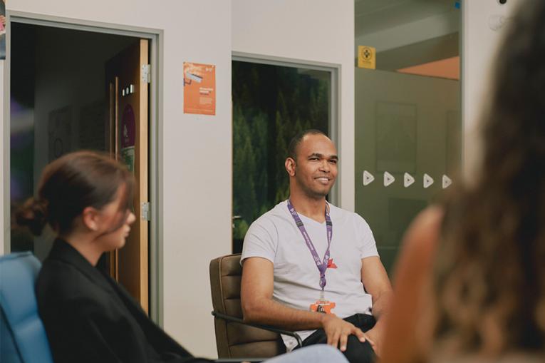 A group of people talking with one person more in focus