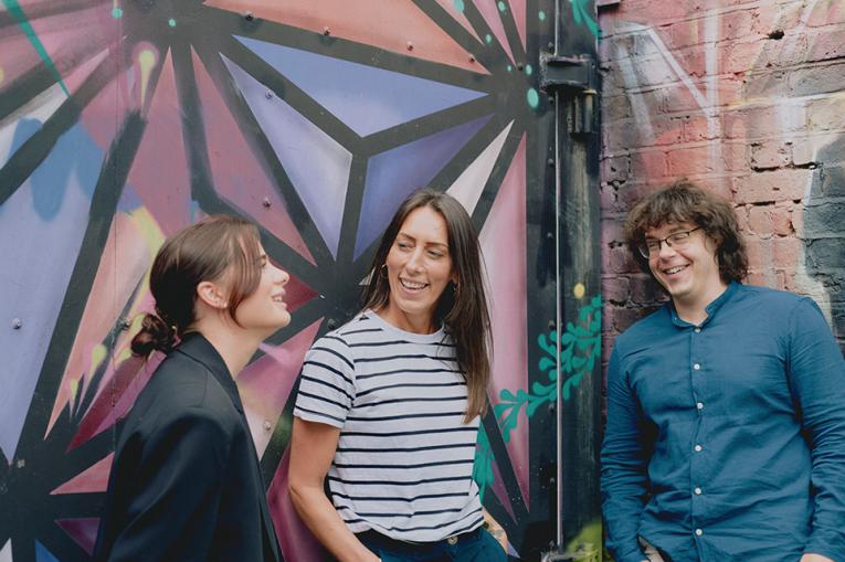 Three people laughing together outside