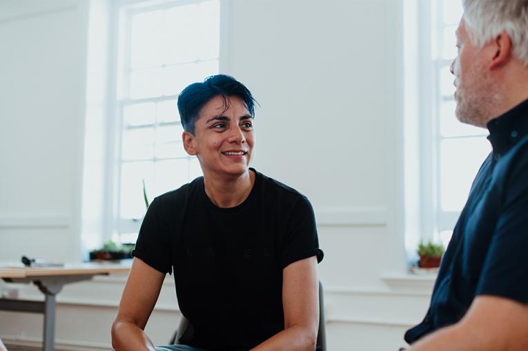 Two people in conversation with one slightly out of focus