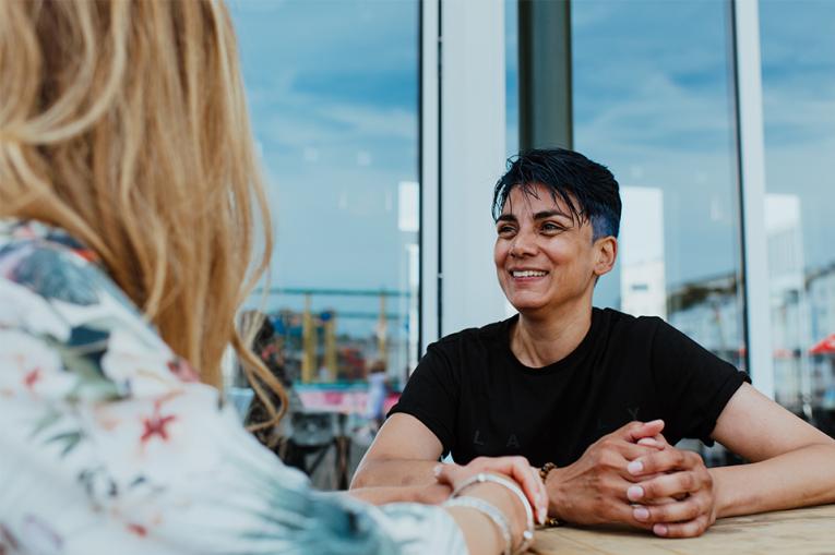 Two people in conversation with one slightly out of focus