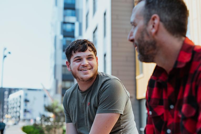 Two people in conversation outside with one slightly out of focus