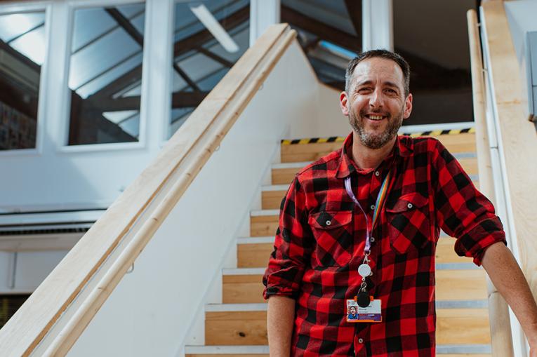 A person standing on the stairs smiling at the camera