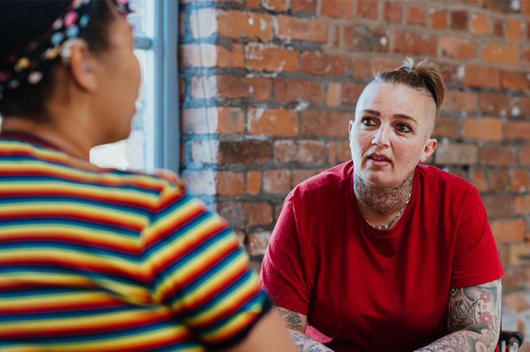 Two people in conversation with one slightly out of focus