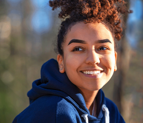 A young girl smiling and looking away from the camera