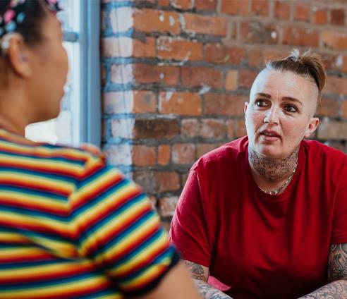 Two people in conversation with one slightly out of focus