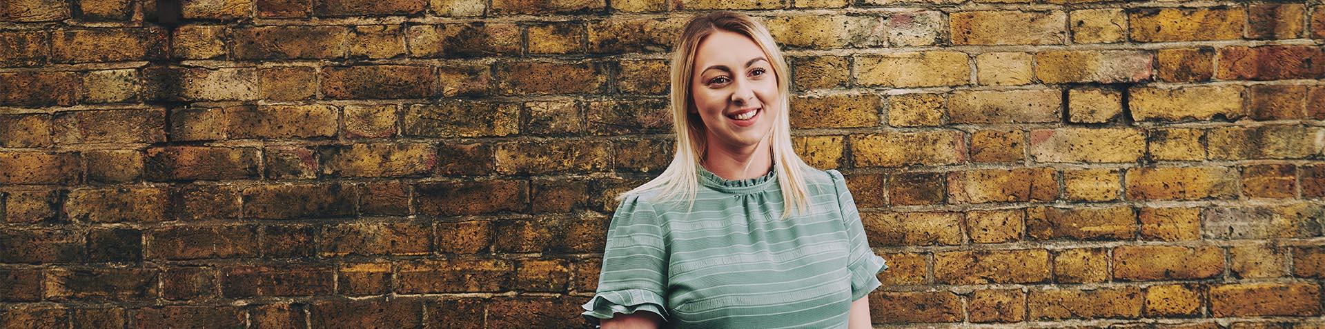 woman smiling in front of a wall