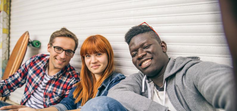 Three young people smiling and looking at camera