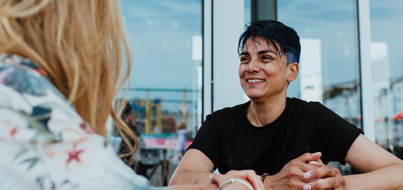 Two people in conversation with one slightly out of focus