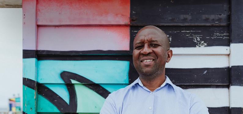 A person smiling outside and looking at the camera