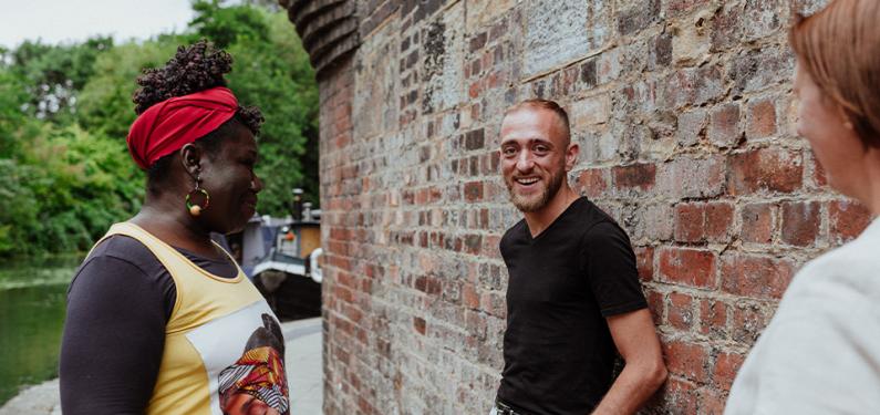 Three people talking with one looking and smiling at the camera