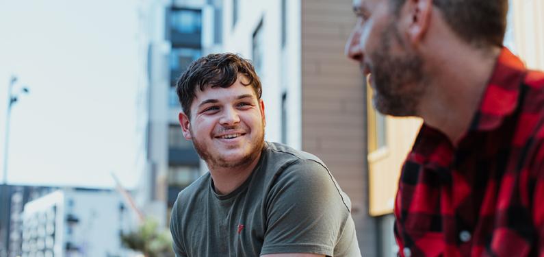 Two people in conversation outside with one slightly out of focus